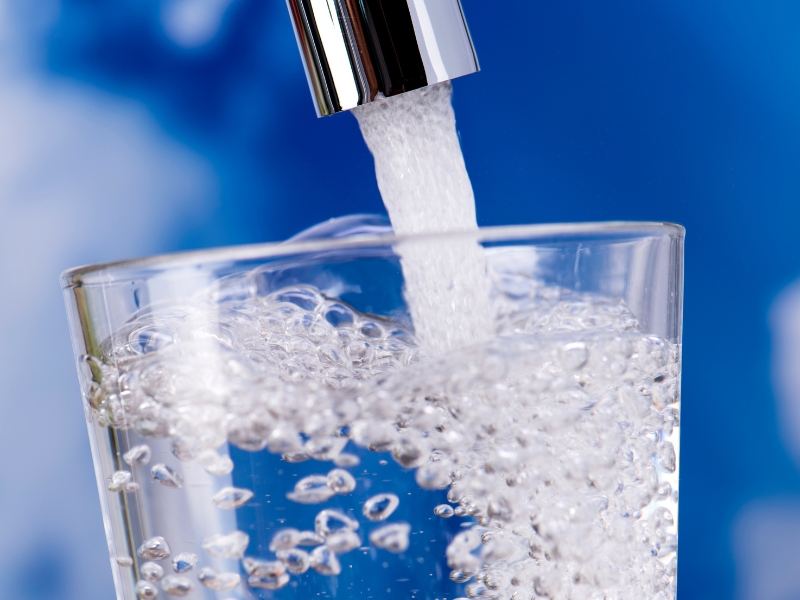 Clear water pouring into glass from tap – Water Filtration System is Best